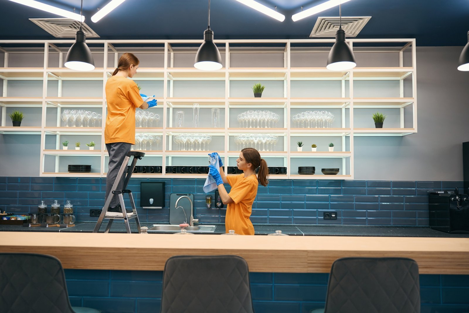 Cleaning company cleaners in process of general cleaning in kitchen in coworking