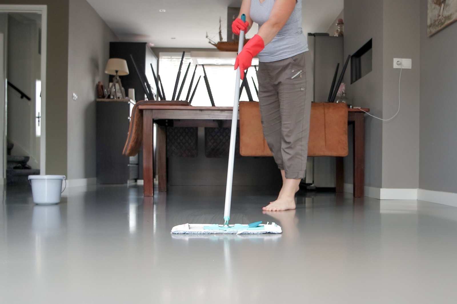 Housekeeper cleaning the floor in the living room.